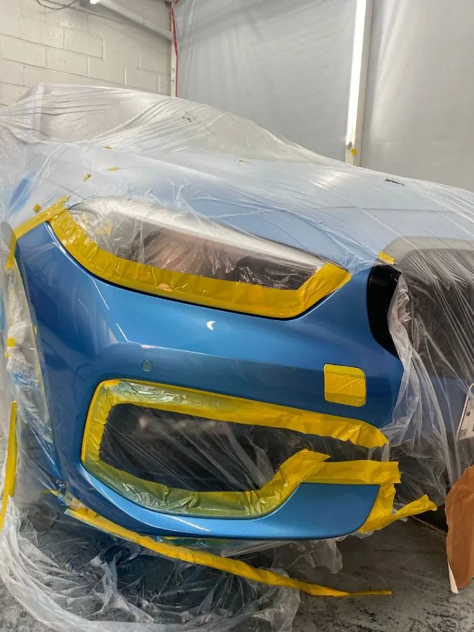 Para-choque de BMW mascarado na cabine de pintura do Spa do Automóvel