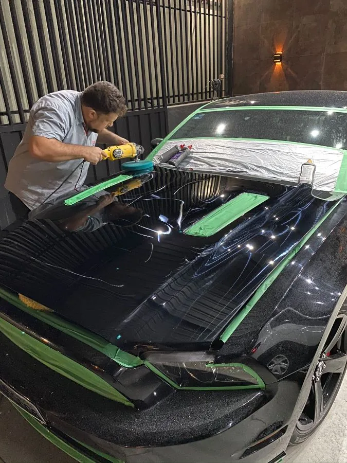 Colaborador do Spa do Automóvel polindo o capô de um veículo com politriz